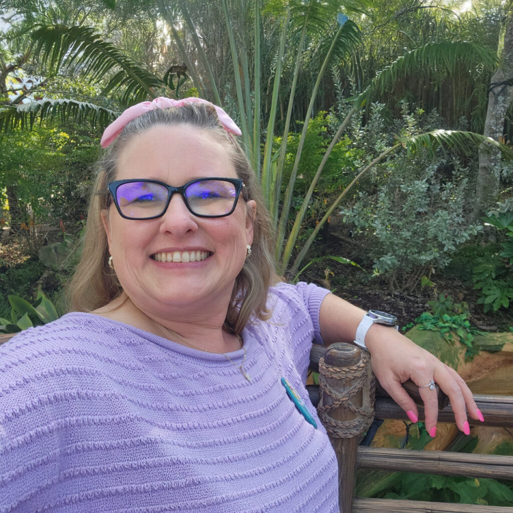 Woman smiling in tropical botanical garden.