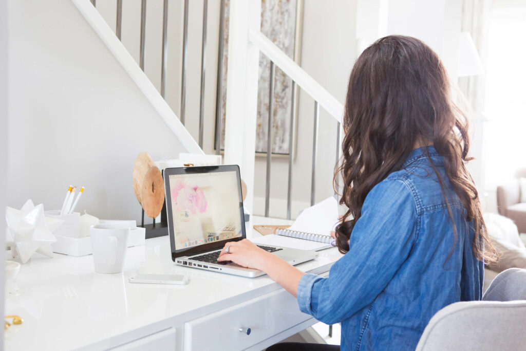 Woman working on laptop in bright home office