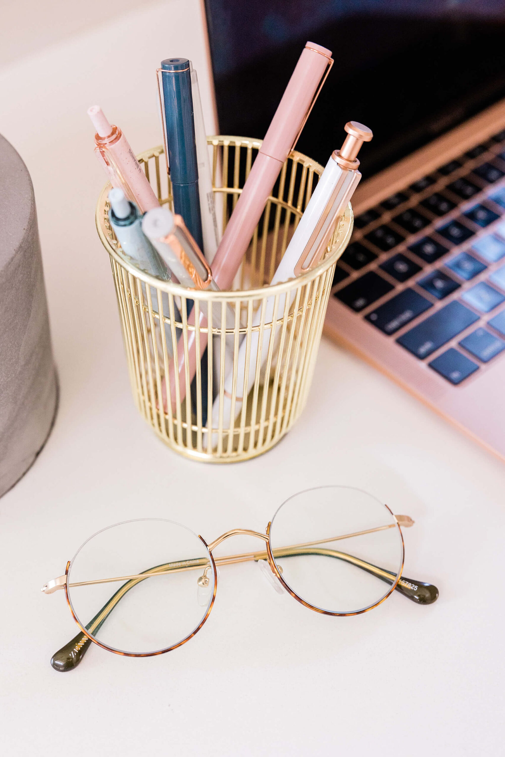 Desk with pens, glasses, and laptop